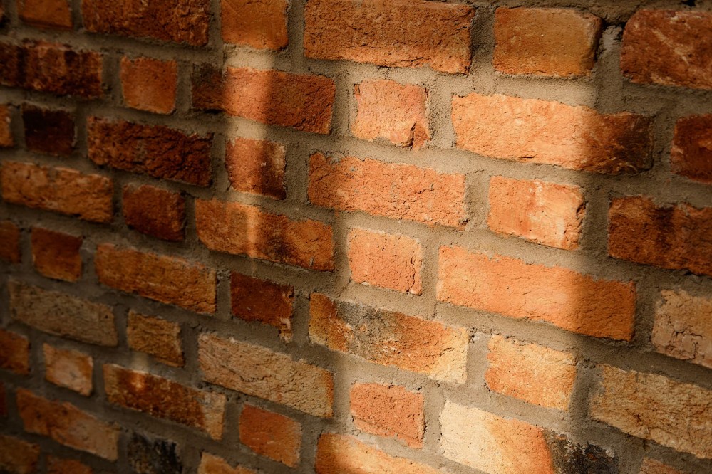 Close-up of orange evening light against a brick wall