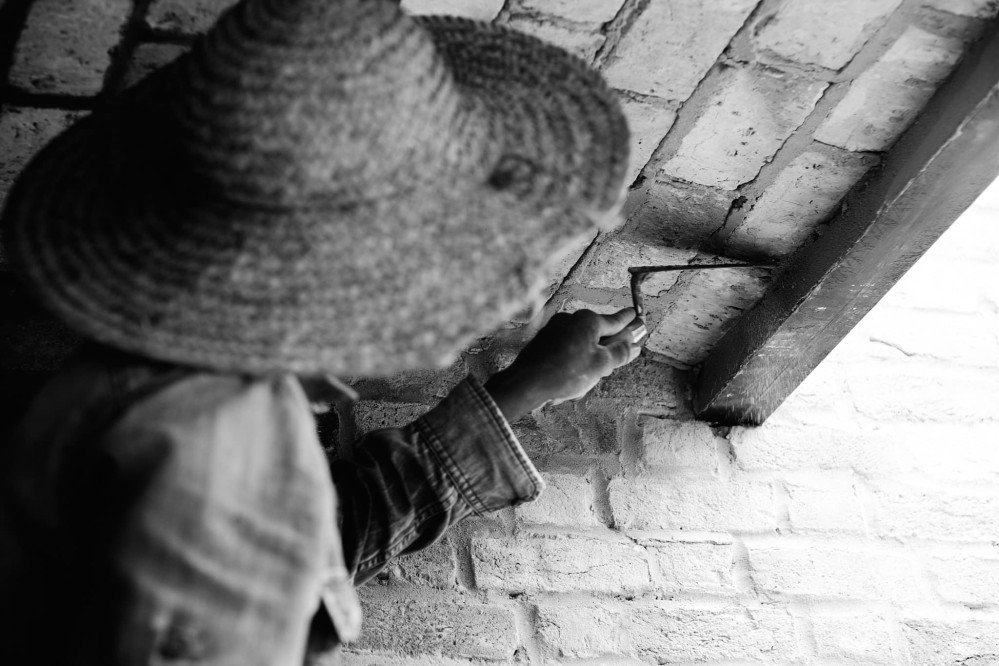 Close-up of bricklayer completing the barell-vaulted brick ceiling