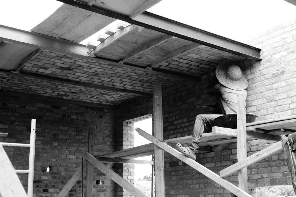A worker completes the barell-vaulted brick ceiling