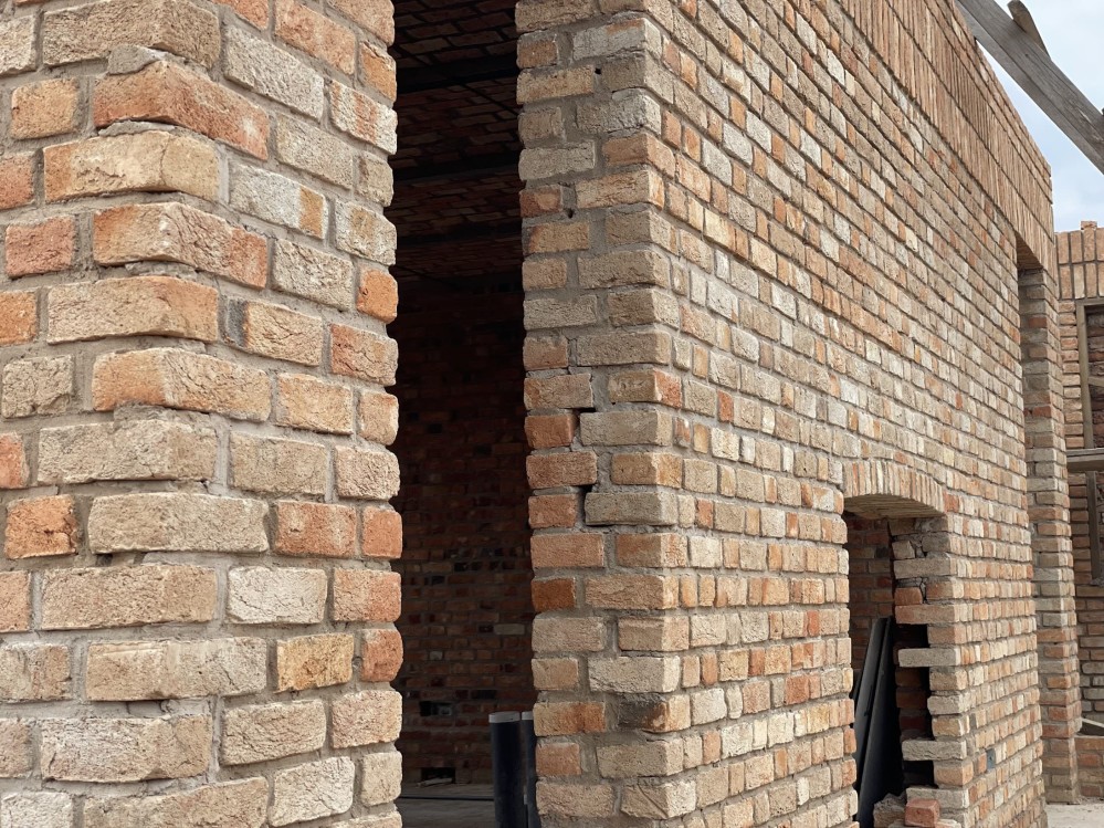 Fireplace and doorway through a brick wall