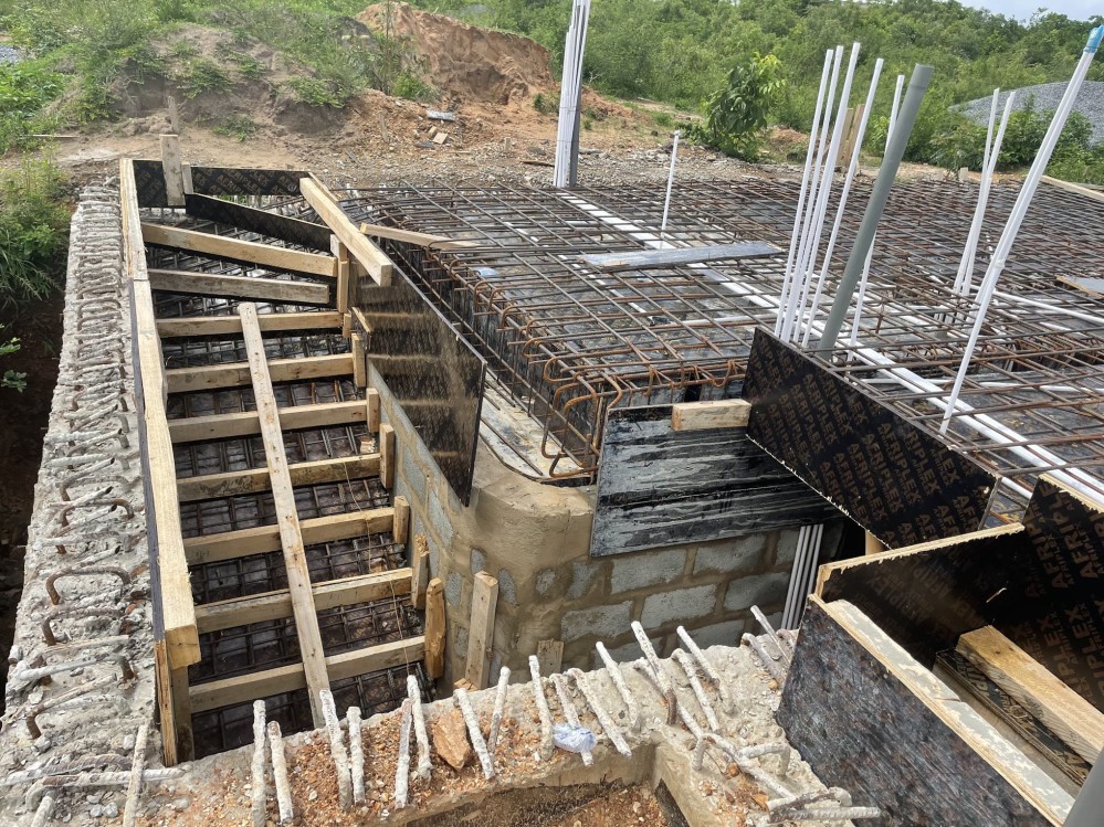 Formwork surrounds the stairs before it was cast. The stairs lead into the basement