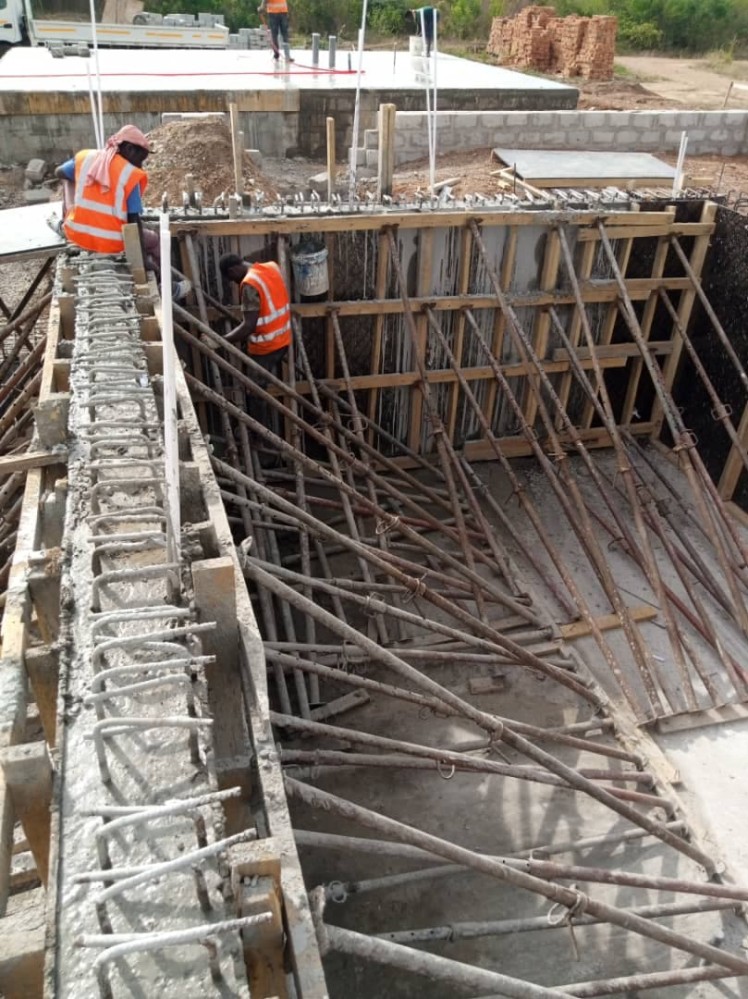 Concrete walls define the basement. The iron rods are embedded within the concrete.