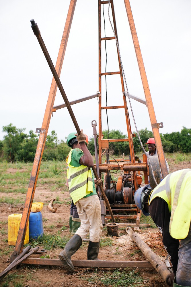 Three men operating the drilling machine