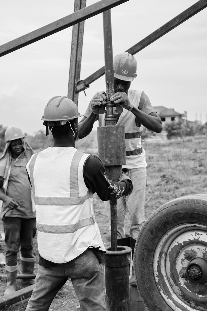 Two men operating the drilling machine